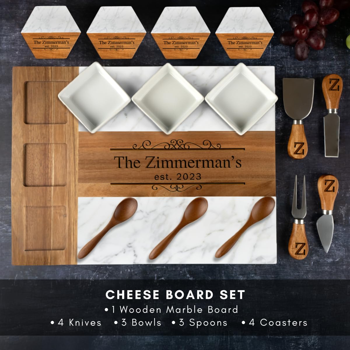 Cheese board set with personalized wooden marble board, knives, bowls, spoons, and coasters on a dark surface.